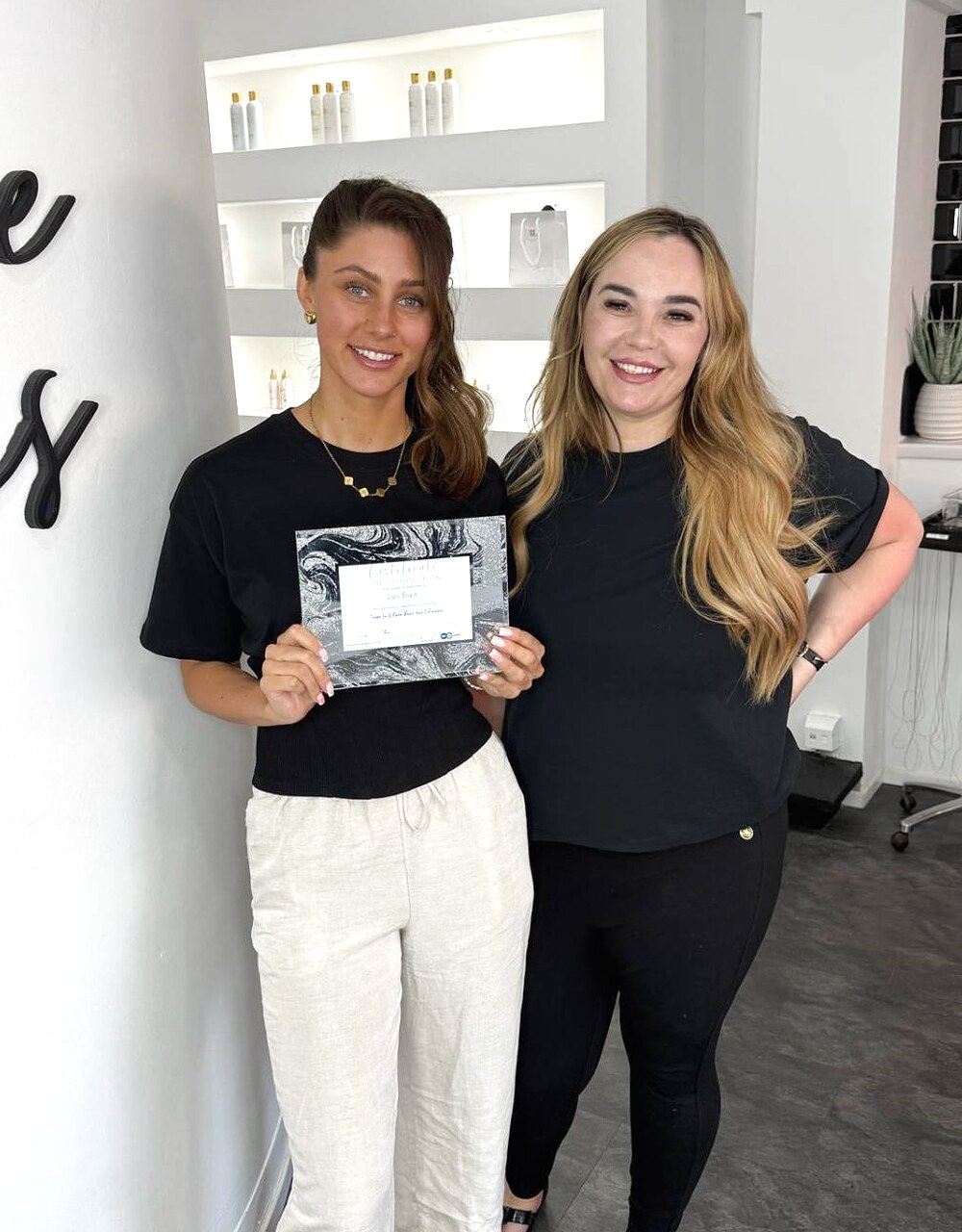 A real Hair Extension Coach student receiving her certificate of completion in the salon